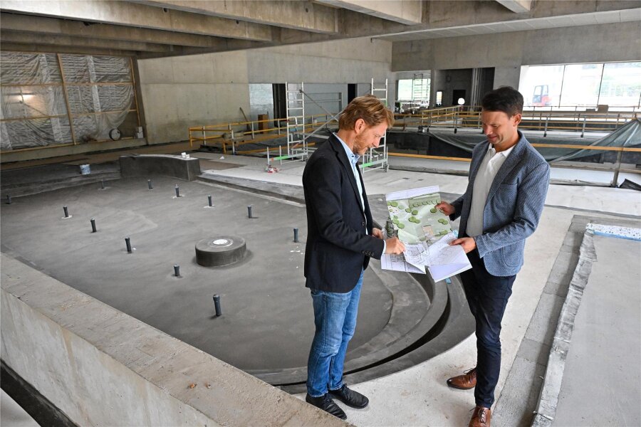 Noch ein Jahr warten: Wann die neue Schwimmhalle in Chemnitz ans Netz gehen soll - Baubürgermeister Michael Stötzer (links) und Norman Schröder, zuständig für die städtischen Bäder, stehen vor dem künftigen Planschbecken – dahinter ist das Lehrschwimmbecken.