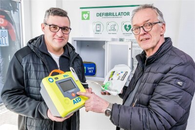 Notfallgerät im Ortszentrum: Defibrillator macht Seiffen herzsicher - René Bellmann und Wolfgang Werner (v. l.) haben den Defibrillator in Betrieb genommen.