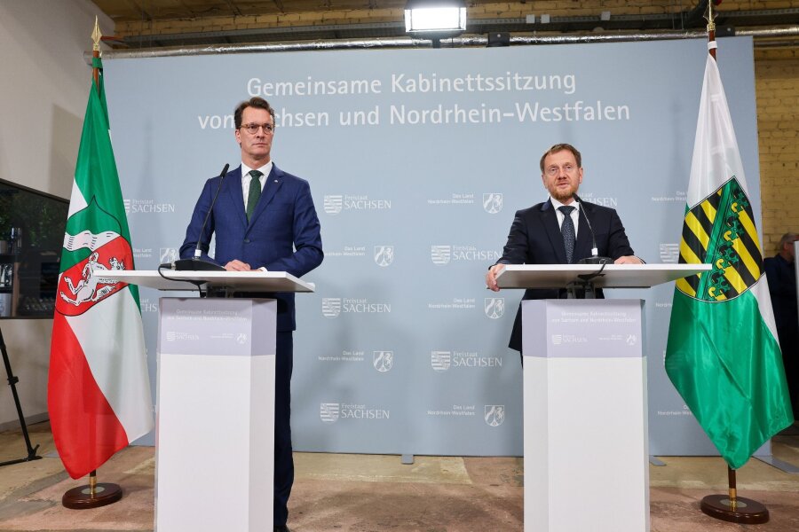 NRW und Sachsen setzen auf stärkeren Austausch - Michael Kretschmer (r, beide CDU), Ministerpräsident von Sachsen, und Hendrik Wüst, Ministerpräsident von Nordrhein-Westfalen, sprechen nach der gemeinsamen Kabinettssitzung der beiden Staatsregierungen in einer Pressekonferenz in der Baumwollspinnerei.