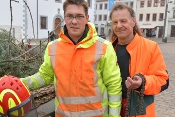 Nun steht auch der Baum am Untermarkt - Jörg Klemm (rechts) und Tim Uhlig hieven die Weihnachtsbäume in ihre Verankerungen. 
