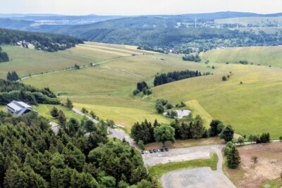 Oberwiesenthal: Naturschützer wollen Ferienhaus-Projekt am Fichtelberg stoppen - Oberhalb der Teiche und direkt unterhalb der Emil-Riedel-Straße sollen die Ferienhäuser entstehen. Ganz links ist das Hotel von Jens Weißflog zu sehen, vorn der Parkplatz "Rotes Vorwerk". 