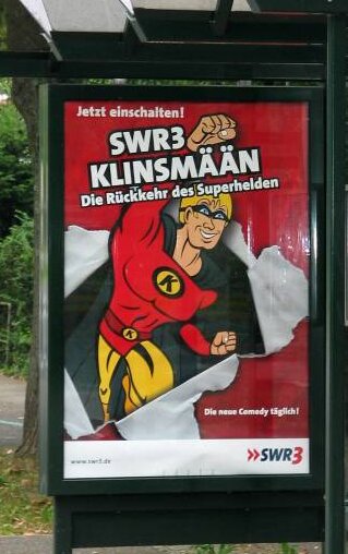 Superhelden gesucht? Ein Werbeplakat für eine Radio-Comedyreihe "Klinsmään - Die Rückkehr des Superhelden" an einer Bushaltestelle. Für eine Reform des Öffentlich-rechtlichen Rundfunks wäre ein Supermann oder eine Superfrau gerade jetzt hilfreich. 