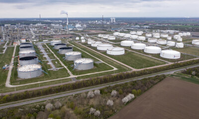 Öl-Embargo: Fünf Punkte, die für Ostdeutschland wichtig werden - Hinter einem Tanklager ragen die Anlagen der Total-Raffinerie in Leuna und des Chemieparks in die Höhe.