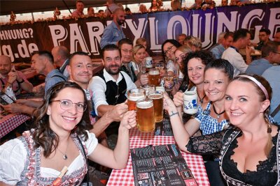 Oktoberfest in Chemnitz gestartet: Was kostet die Maß Bier auf der „Wooosn“? - Zünftig und in Tracht: Auf dem Hartmannplatz wird bis Ende September Oktoberfest gefeiert.