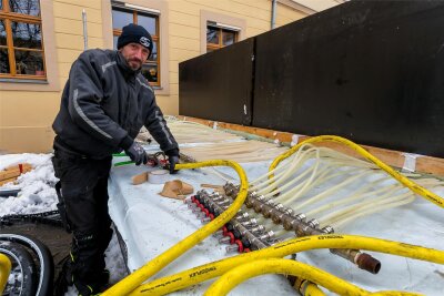 Olbernhau betreibt erstmals Eisbahn selbst: Das sind die Preise und Öffnungszeiten - Eisarena-Mitarbeiter Sebastian Hähnel bereitet die Armaturen für die Vereisung vor.