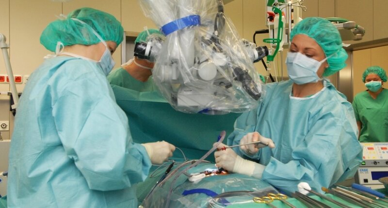 Operateure schauen seit Mittwoch durch neue Augen - 
              <p class="artikelinhalt">Im Operationssaal 3 legt Ärztin Katrin Oertel (rechts) den verengten Wirbelkanal frei. Durch das Mikroskop lassen sich die Details des Eingriffs verfolgen. )</p>
            