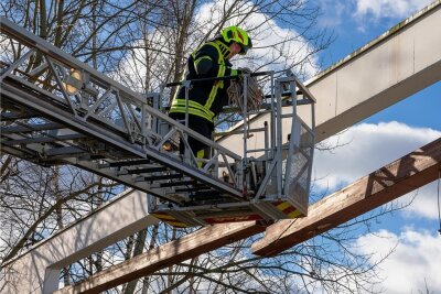 Orkantief: Rund um Stollberg fallen Bäume auf Straßen, Häuser und Gleise - In Lugau sicherte die Feuerwehr einen gebrochenen Holzbalken am Paletti-Park und brachte ihn auf den Boden. 