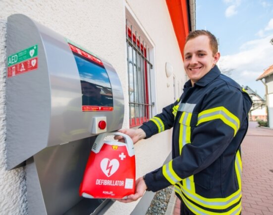 Notfallsanitäter Tim Ostenhausen kann zufrieden lächeln: Nun befindet auch am Adorfer Feuerwehrgebäude ein Defibrillator. 
