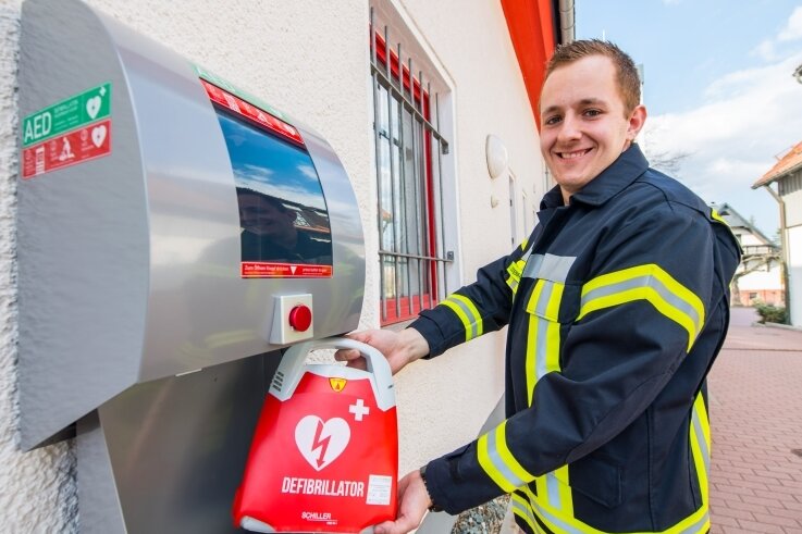 Ortsteil Adorf wird herzsicher - Notfallsanitäter Tim Ostenhausen kann zufrieden lächeln: Nun befindet auch am Adorfer Feuerwehrgebäude ein Defibrillator. 