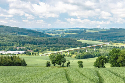 Links Falkenau, rechts Flöha, in der Mitte eine große Brücke. Etwa so könnte es aussehen, wenn der zweite Streckenabschnitt der Ortsumfahrung der Bundesstraße 173 gebaut worden ist. Die Bauart der Brücke wurde in dieser Montage einer Visualisierung des Sächsischen Verkehrsministeriums nachempfunden.
