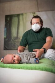 Osteopathie hilft Baby Paul - Osteopath Markus Weslowski tastet am Körper des fünf Wochen alten Paul nach Blockaden. 