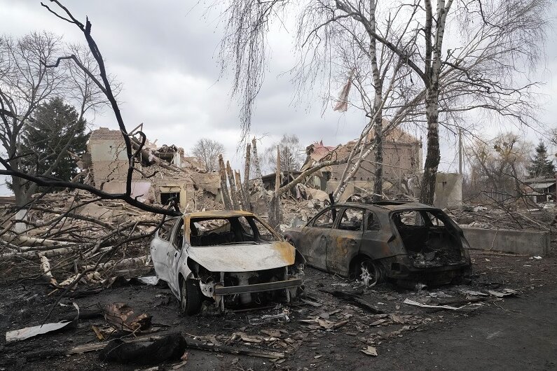 Ukraine, Makariw: Zerstörte Autos stehen vor einem zerstörtem Haus nach einem schweren nächtlichen Gefecht, 40 Kilometer westlich von Kiew.