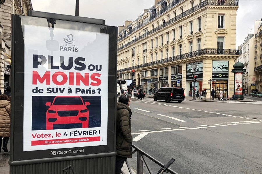 Parken in Paris teurer: Auch in Leipzig möchte man an der Preisschraube drehen - Paris, im Dezember 2023: Auf einer Werbetafel informiert die Stadt über eine Bürgerbefragung zu erhöhten Parkgebühren für SUV.