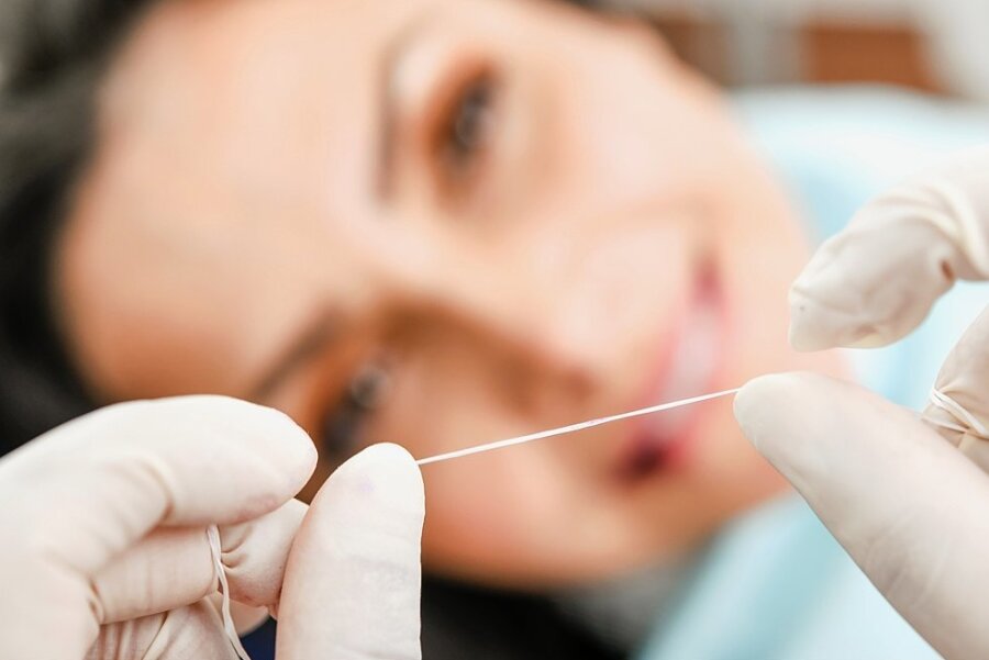 Ohne Zahnseide geht es nicht. Die Handhabung erklären Prophylaxe-Assistentinnen beim regelmäßigen Kontrolltermin. 
