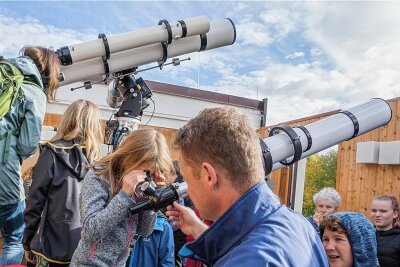 Partielle Sonnenfinsternis: Hochbetrieb an den Teleskopen der Sternwarte Drebach - In der Sternwarte wuselten mitunter bis zu 30 Besucher herum, um durch die Teleskope einen Blick auf die vom Mond "angeknabberte" Sonnenscheibe zu erhaschen. Jens Kandler (vorn) behielt den Überblick.