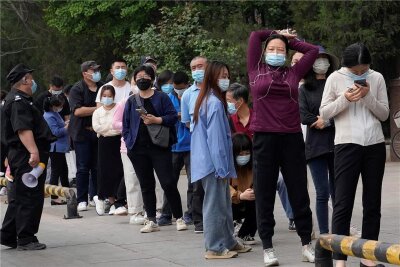 Peking droht ein Lockdown wie in Shanghai - Schlangestehen für einen Coronatest in Peking. 
