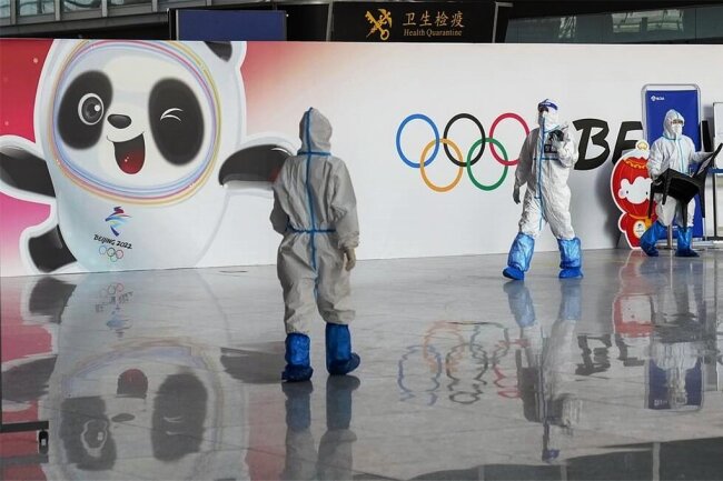 Peking zwischen Prunk und Pandemie: Olympia erneut im Zeichen von Corona - Bilder von Mitarbeitern in weißer Schutzkleidung wie auf dem Flughafen werden bei den Winterspielen in Peking allgegenwärtig sein. 