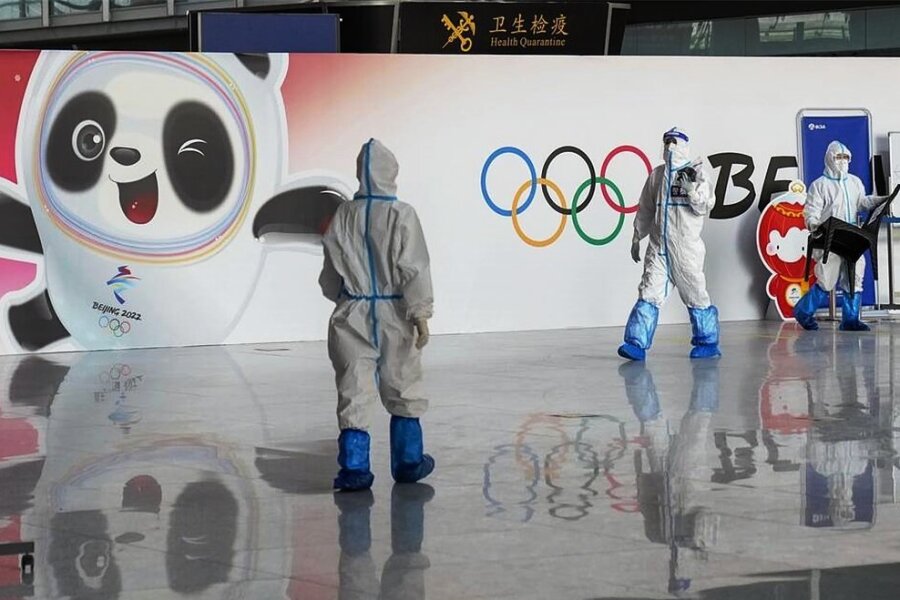 Peking zwischen Prunk und Pandemie: Olympia erneut im Zeichen von Corona - Bilder von Mitarbeitern in weißer Schutzkleidung wie auf dem Flughafen werden bei den Winterspielen in Peking allgegenwärtig sein. 