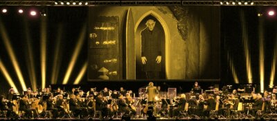 Philharmoniker lehren jetzt das Gruseln - Nein, Graf Orlok sucht unter den Musikern kein Opfer. Dennoch darf ihn der Dirigent auf der Leinwand nie ganz aus den Augen lassen, um den Einsatz nicht zu verpassen.