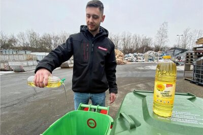 Pilotprojekt in Crimmitschau: Entsorgungsfirma nimmt Altfette und Öle von Privathaushalten an - Mitarbeiter Roman Pocinok entsorgt altes Speiseöl in dem dafür aufgestellten Behälter in Crimmitschau. 