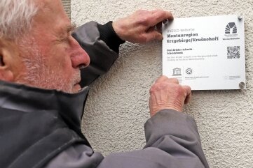 Plakette verkündet: Hier ist Welterbe - Reiner Hoffmann bringt die Unesco-Plakette am Drei-Brüder-Schacht an.