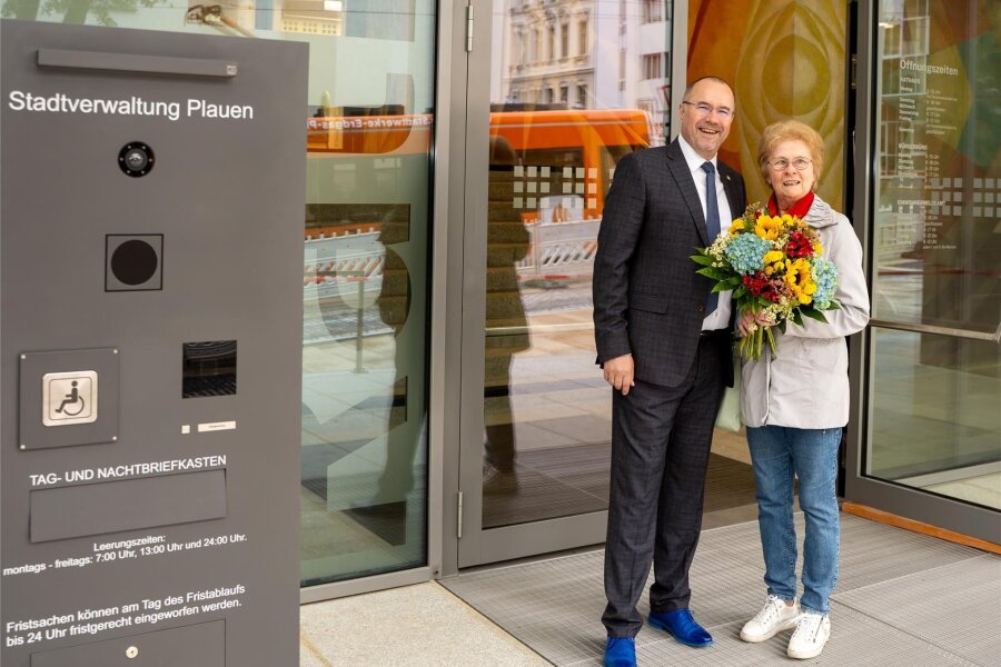 Plauener Rathauseingang nach mehrjähriger Sanierung für Besucher wieder offen - Birgitt Vogel war am Montag die erste Bürgerin der Stadt, die den sanierten Rathauseingang betreten konnte. OB Steffen Zenner begrüßte sie herzlich und überreichte ihr einen Blumenstrauß.