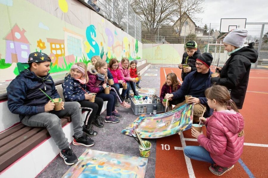 Plauener Schul-Sportplatz bekommt eine bunte Wand - Während der Osterferien haben Hortkinder an der Grundschule Neundorf mit Graffitikünstler André Wolf kreativ gearbeitet. 