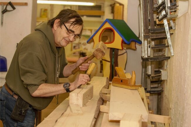 In der Holzwerkstatt arbeitet Hobbytischler Frank Winkelmann am liebsten. Im Hintergrund: ein Vogelhäuschen im Stil des fantasievollen Künstlers Friedensreich Hundertwasser. 