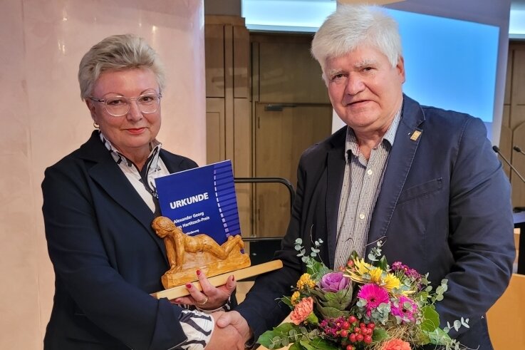 Werner Beuschel, Vorsitzender der DOG-Stadtgruppe Zwickau, übergibt die Trophäe an Huster-Geschäftsführerin Ulla Reichel. 