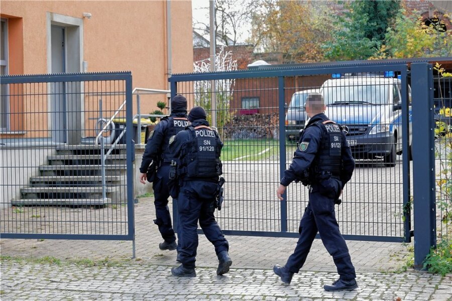Polizei durchsucht mehrere Objekte in Chemnitz - Polizeibeamte betreten das Grundstück eines der durchsuchten Objekte an der Adelsbergstraße in Chemnitz. 