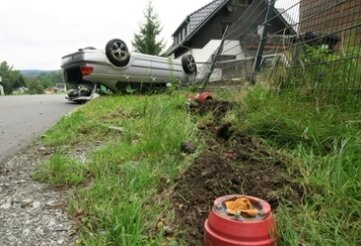 Polizei sucht nach Unfallverursacher - Bei einem Unfall in Raschau-Markersbach landete ein Auto auf dem Dach an einem Zaun. 