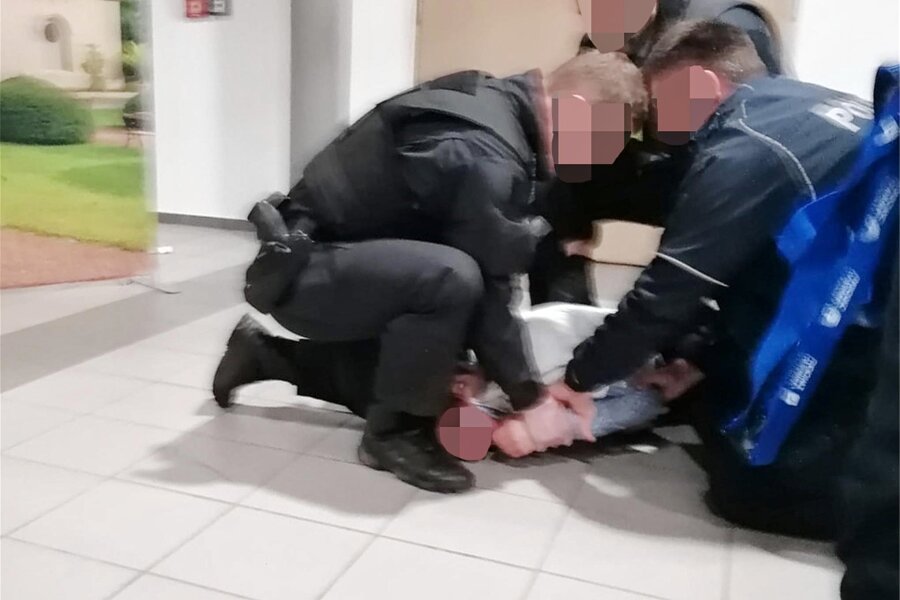 Polizeieinsatz nach Zwickauer Kreistagssitzung: Beamte überwältigen 16-Jährige - Drei Polizisten fixieren das 16-jährige Mädchen in der Sachsenlandhalle in Glauchau. Dabei brach die Jugendliche einem Beamten einen Finger.