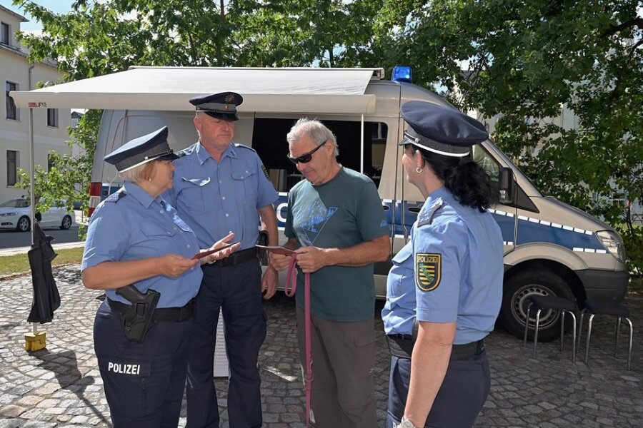 Klaus Ungethüm (Mitte, rechts) hat am Polizeimobil in Eibenstock vorbeigeschaut und kam ins Gespräch mit Kerstin Schröder (links), Bürgerpolizist Frank Groß und Kathy Seyferth. 