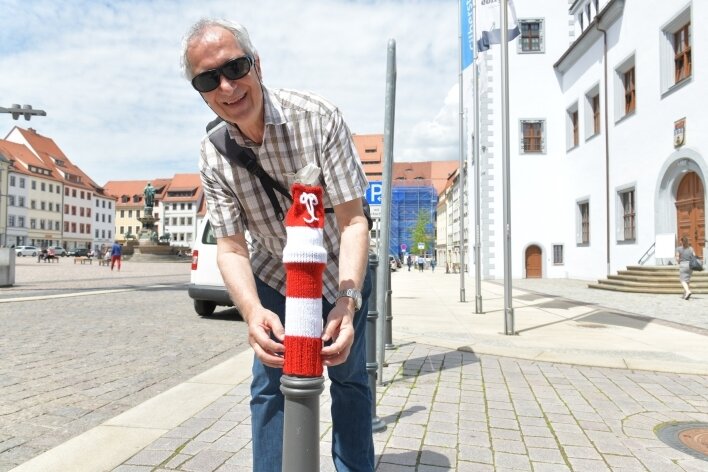 Poller bekommen Mützen - Wolfgang Neuber, Chef der Kreisorganisation Freiberg des Blinden- und Sehbehindertenverbandes, hat probehalber einem Poller auf dem Freiberger Obermarkt eine Mütze aufgesetzt. 
