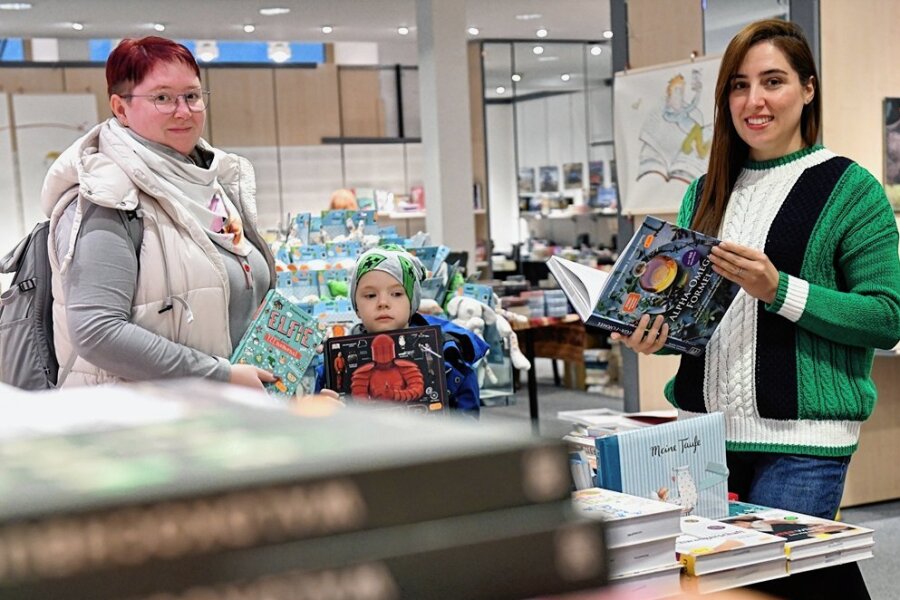 Pop-up-Buchladen auf Freiberger Einkaufsmeile eröffnet - In der temporären Buchzentrale in der Burgstraße berät Soheila Seyedghaleh (r.) Melanie Enzmann mit Sohn Vincent (6). 
