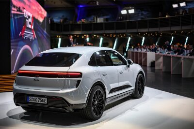 Porsche startet dieses Jahr seine größte Produktoffensive - welche Modelle künftig in Leipzig gebaut werden - Der neue elektrische Porsche E-Macan steht während der Bilanzpressekonferenz des Unternehmens im Werk Leipzig mit auf dem Podium.