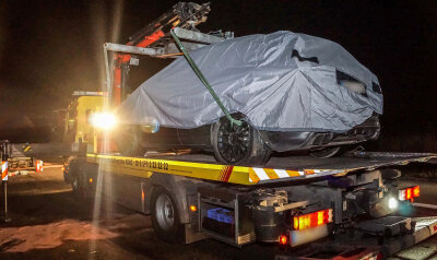 Das Porsche-Testfahrzeug wird nach einem schweren Unfall abgedeckt auf der Autobahn 81 bei Rottenburg (Baden-Württemberg) auf einen Abschleppwagen gehoben. 