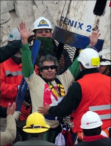 PORTRÄT: Ältester Kumpel schafft es als Neunter nach oben - Chilean miner Mario Gomez waves upon exiting the Fenix capsule after being brought to the surface in the ninth place, on October 13, 2010 following a 10-week ordeal in the collapsed San Jose mine, near Copiapo, 800 km north of Santiago, Chile. AFP PHOTO/ MARTIN BERNETTI