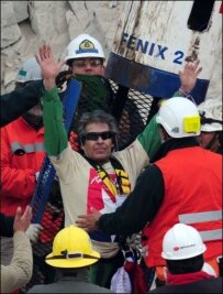 PORTRÄT: Ältester Kumpel schafft es als Nummer 9 nach oben - Chilean miner Mario Gomez waves upon exiting the Fenix capsule after being brought to the surface in the ninth place, on October 13, 2010 following a 10-week ordeal in the collapsed San Jose mine, near Copiapo, 800 km north of Santiago, Chile. AFP PHOTO/ MARTIN BERNETTI