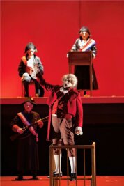 Premiere in Gera: Der Unverstand gelenkter Massen in einer vergessenen Oper - Traditionelle Kostüme vor blutrotem Hintergrund: Szene aus "Dantons Tod" im Theater Gera. 