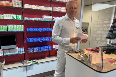 Probleme mit dem E-Rezept: Apotheker in Westsachsen zwischen Verzweiflung und Hoffnung - Apotheker Reinhard Groß hält in seiner Hand einen Stoß von Papier-Rezepten, der sich in nur drei Stunden angehäuft hat.