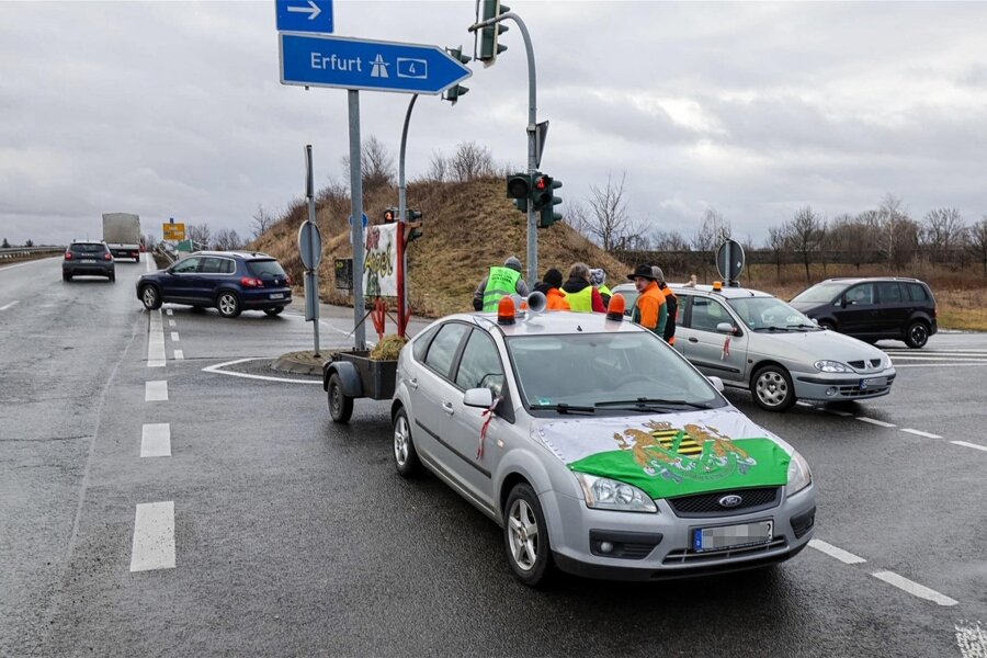 Proteste im Landkreis Zwickau am Donnerstag: Traktoren blockieren A-4-Auffahrt Glauchau-Ost - Am Donnerstagmorgen blockierte unter anderem ein Auto mit Fahne der „Freien Sachsen“ und Plakat-Anhänger die A-4-Auffahrt Glauchau-Ost.