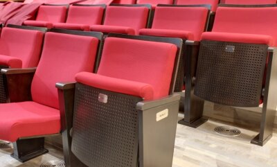 Publikum sitzt auf Stühlen aus Italien - Breitere Sitze und wesentlich mehr Beinfreiheit als vorher.