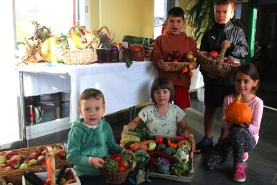 Pusteblumen-Kinder feiern Erntedank - Emil (5), Emma (5), Lotta (v.l.), Ludwig (6, hinten li.) und Oskar (8) haben von zu Hause Obst und Gemüse für das Erntedankfest im Kindergarten mitgebracht.