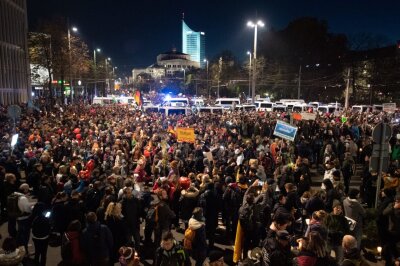 "Querdenken": Chaos in Leipzig - Teilnehmer stehen nach der Demo umgeben von Einsatzfahrzeugen der Polizei am Leipziger Hauptbahnhof.