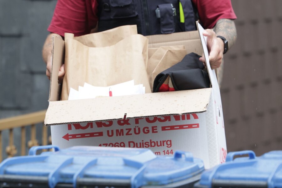 Razzia gegen Hamas-Unterstützergruppe in Duisburg - Ein Polizist trägt nach einer Wohnungsdurchsuchung einen Karton mit sichergestellte Gegenständen.