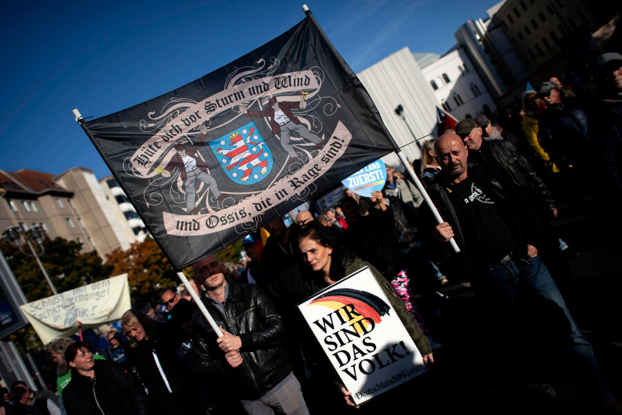Bei der AfD-Demonstration am 8. Oktober 2022 in Berlin waren die Bekenntnisse vielfältig. Sie reichten von der AfD-Kampagne "Unser Land zuerst" über vereinnahmte Wende-Slogans und Kampfsprüche wie "Hüte Dich vor Sturm und Wind und Ossis, die in Rage sind" bis hin zur SS-Huldigung mit dem Emblem der Schwarzen Sonne. 