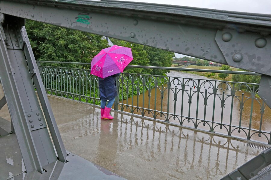 Regen lässt die Zwickauer Mulde wachsen - Regenschirm und Gummistiefel: So sah am Montag das passende Outfit in Zwickau aus. 