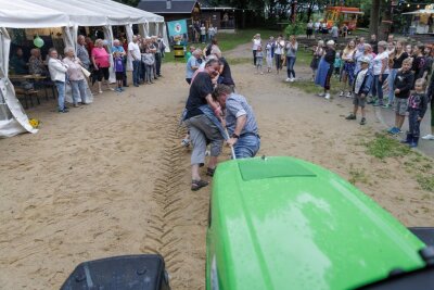 Regen platzt in Cunersdorfer Waldfest - Aus dem geplanten Wettkampf wurde eine Gaudi: Drei Teams zogen einen Traktor über eine festgelegte Strecke.