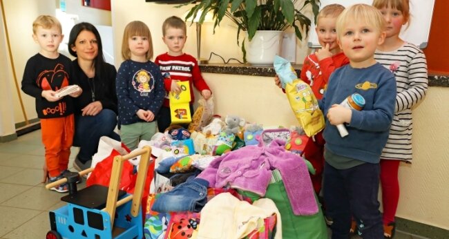 Die Kinder aus der "Mäuse-Gruppe" begutachten mit Cathleen Herold die ersten Spenden, die für Kinder aus der Ukraine bestimmt sind. 